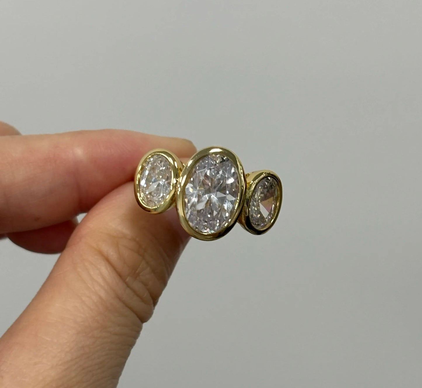 8ct Oval Cut White Sapphire Three-Stone Ring in Elegant Bezel Setting